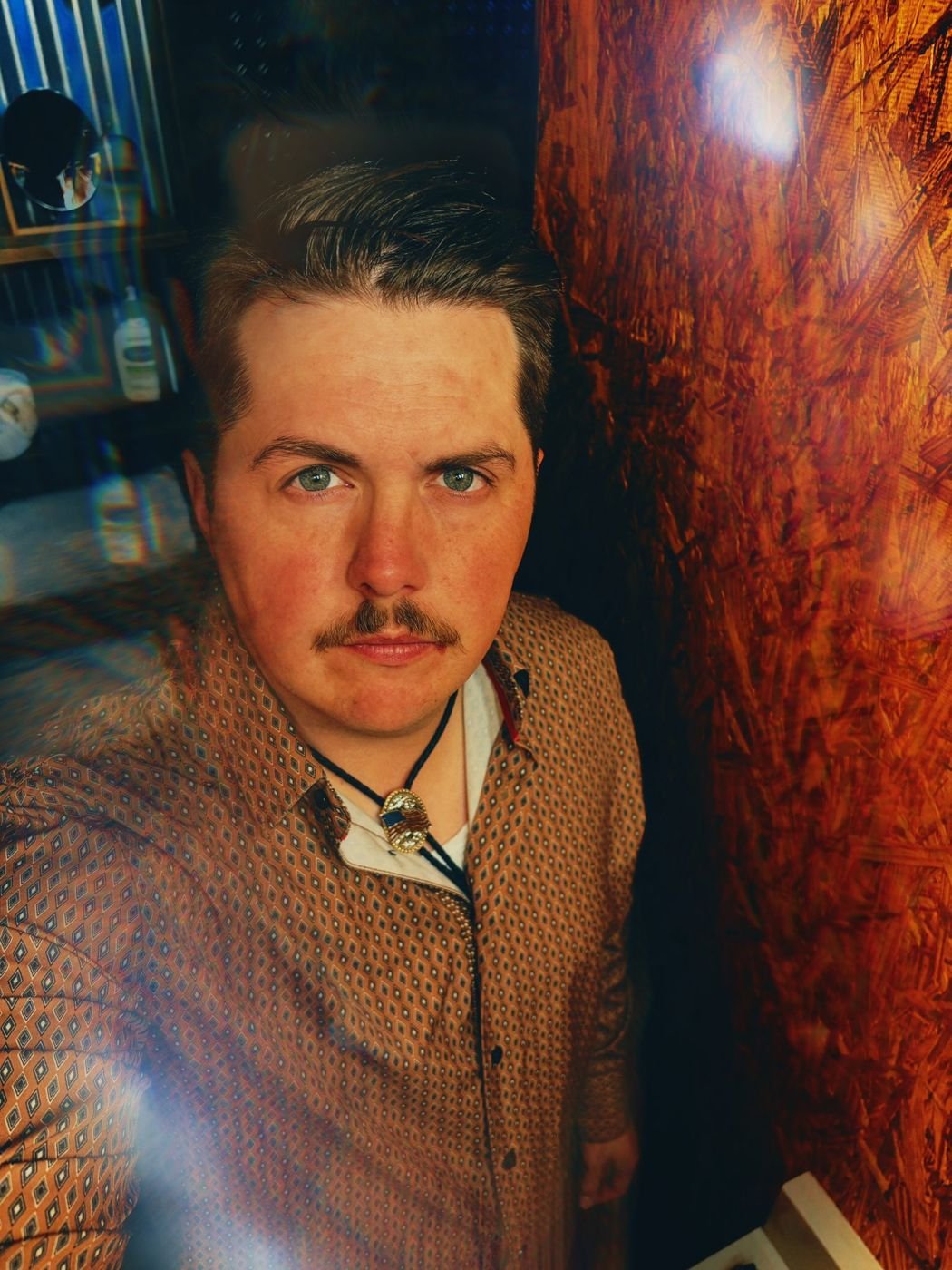 Portrait of Jake Black wearing a patterned shirt and bolo tie